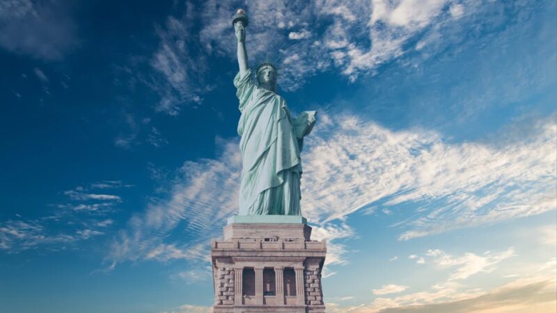 Iconic Statue of Liberty with a backdrop of a vibrant blue sky, symbolizing freedom and America.